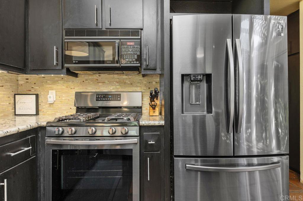 29560 Lilac Road Valley Center, CA 92082 - Photo 11 of 43 a kitchen with stainless steel appliances granite countertop a stove microwave and refrigerator