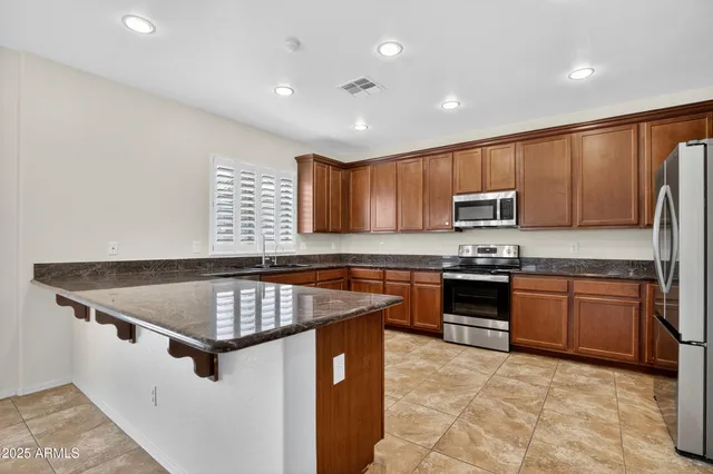 a kitchen with stainless steel appliances granite countertop a sink dishwasher stove and refrigerator