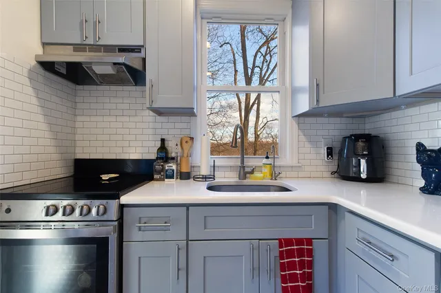 a kitchen with a stove and a white cabinets