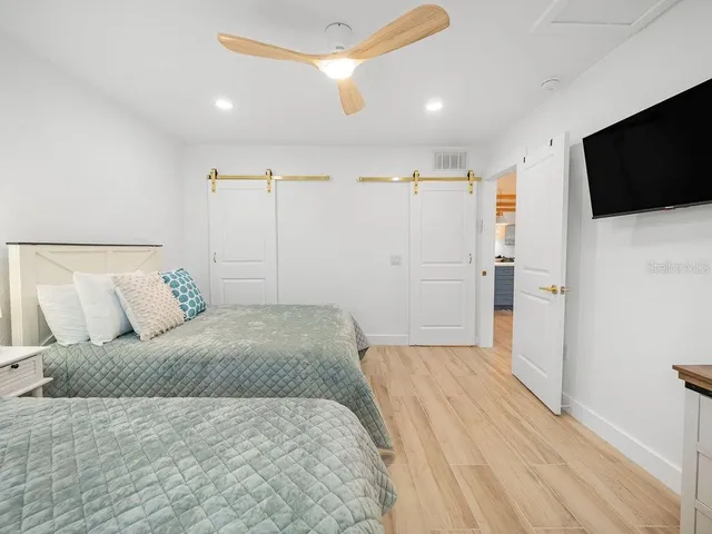 a bedroom with a large bed and a flat screen tv