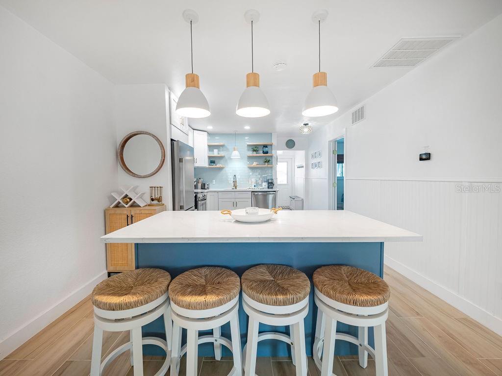 449 63rd Street Holmes Beach, FL 34217 - Photo 22 of 54 a kitchen with a dining table and chairs