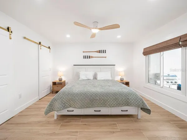 a bedroom with a bed and a large window