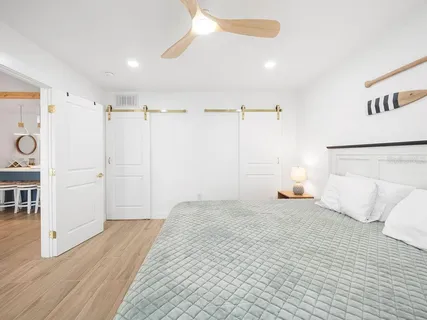 a view of a bedroom with wooden floor and window