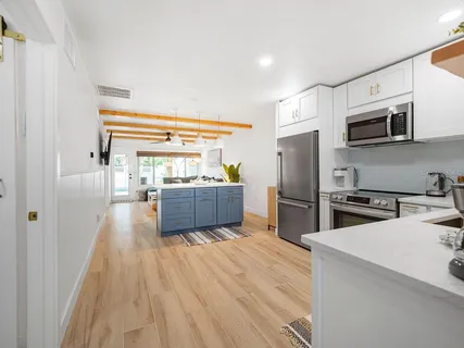 a kitchen with stainless steel appliances a refrigerator sink and microwave