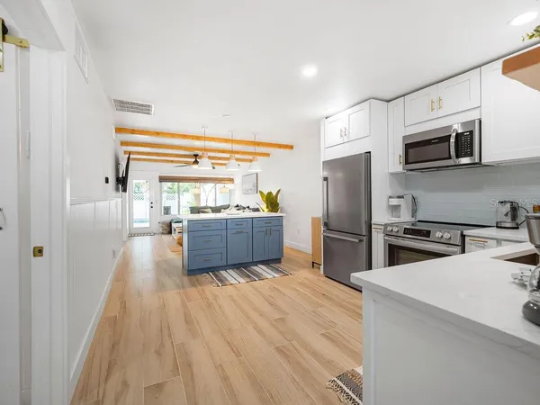 a kitchen with stainless steel appliances a refrigerator sink and microwave