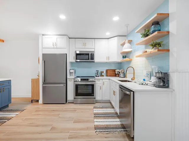 a kitchen with kitchen island a sink stainless steel appliances and counter space