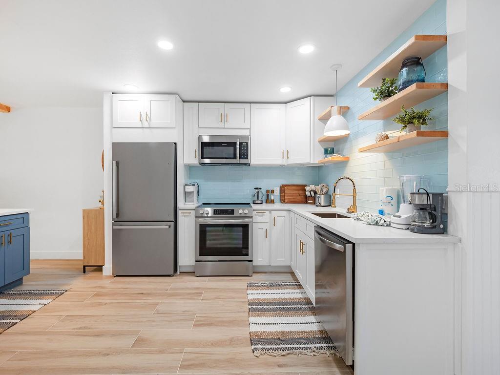 449 63rd Street Holmes Beach, FL 34217 - Photo 5 of 54 a kitchen with kitchen island a sink stainless steel appliances and counter space