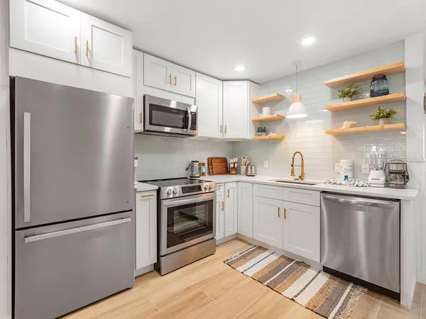 a kitchen with stainless steel appliances a refrigerator sink and microwave