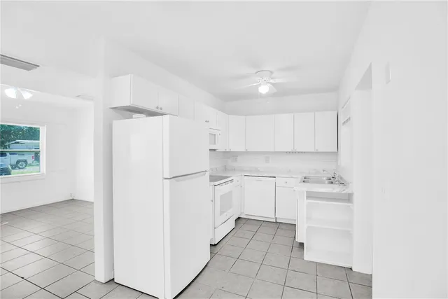 a kitchen with a refrigerator and white cabinets