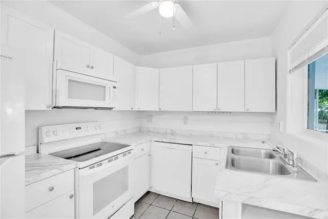 a kitchen with white cabinets appliances and sink