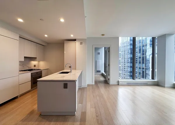 a kitchen with a sink and wooden floor