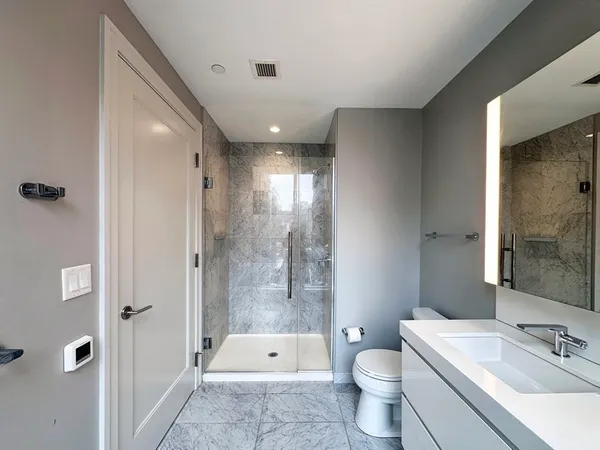 a bathroom with a sink a toilet and shower