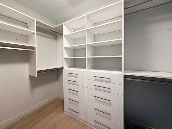 a view of walk in closet with empty racks