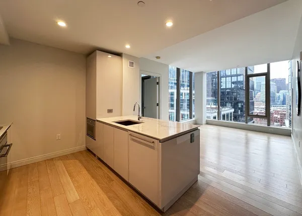 a large kitchen with stainless steel appliances granite countertop a large counter top and a wooden floors