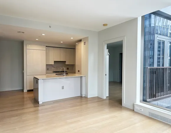 a open kitchen with white cabinets and a refrigerator