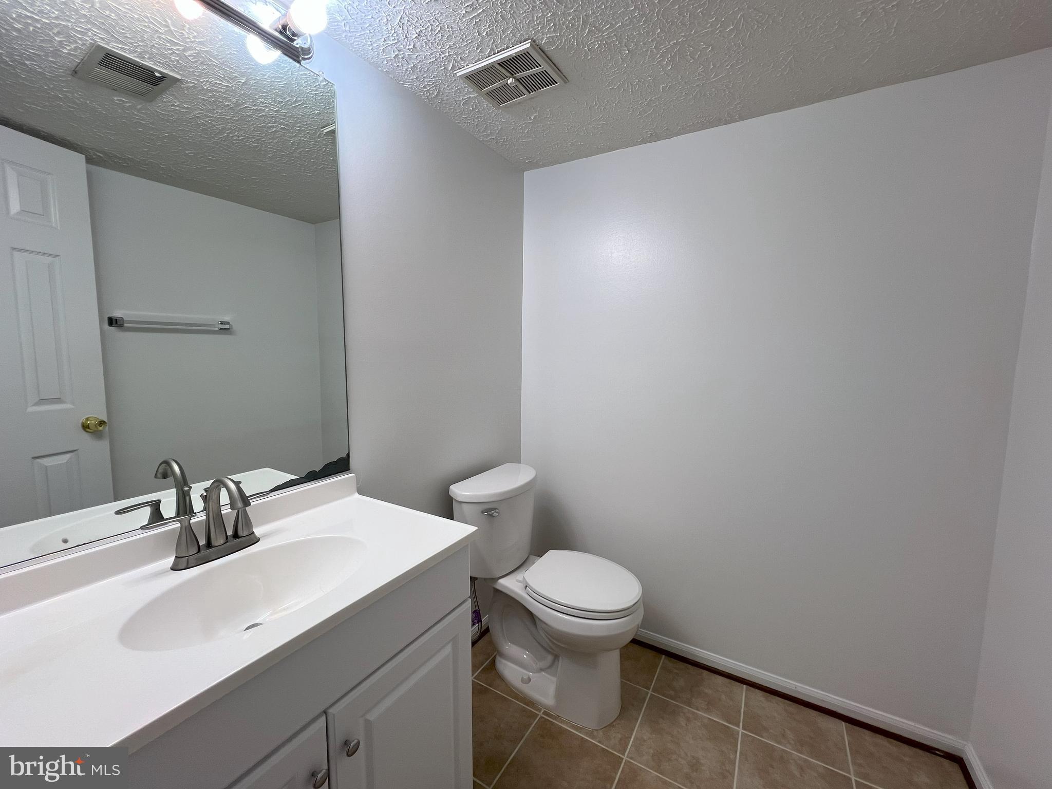 14027 Great Notch Terrace North Potomac, MD 20878 - Photo 19 of 27 a bathroom with a sink mirror and toilet