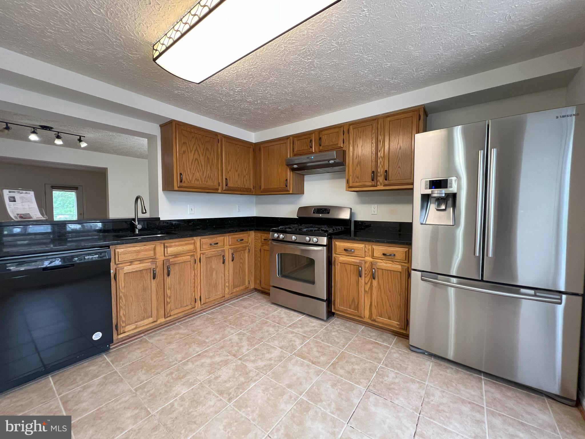 14027 Great Notch Terrace North Potomac, MD 20878 - Photo 3 of 27 a kitchen with granite countertop a refrigerator stove top oven and sink