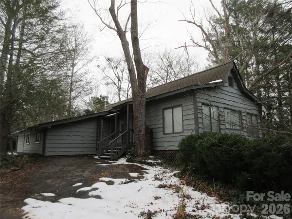 a front view of house with yard and trees around