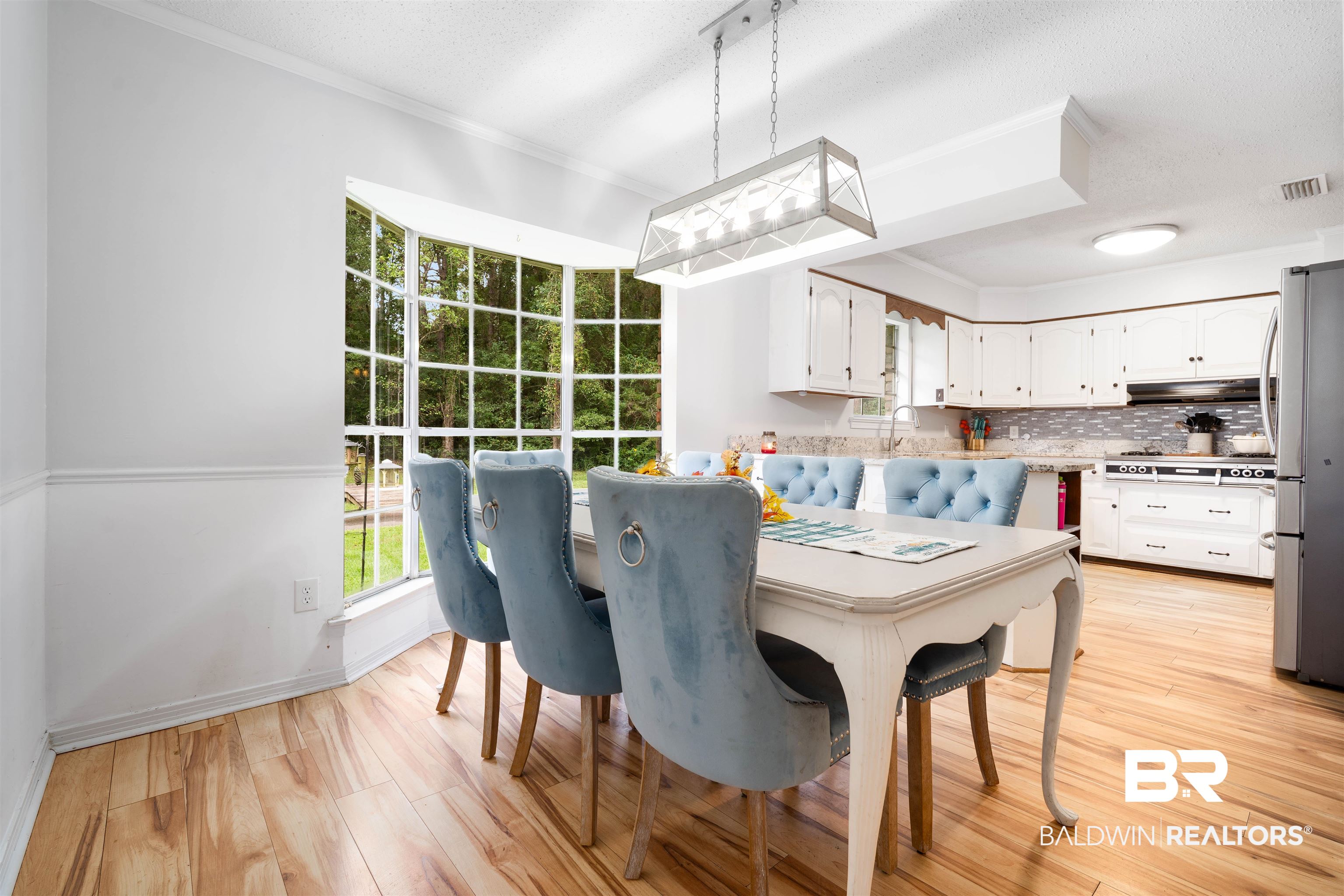 7807 Yorkhaven Road Mobile, AL 36695 - Photo 10 of 34 Dining space featuring crown molding, light wood-type flooring, and a textured ceiling