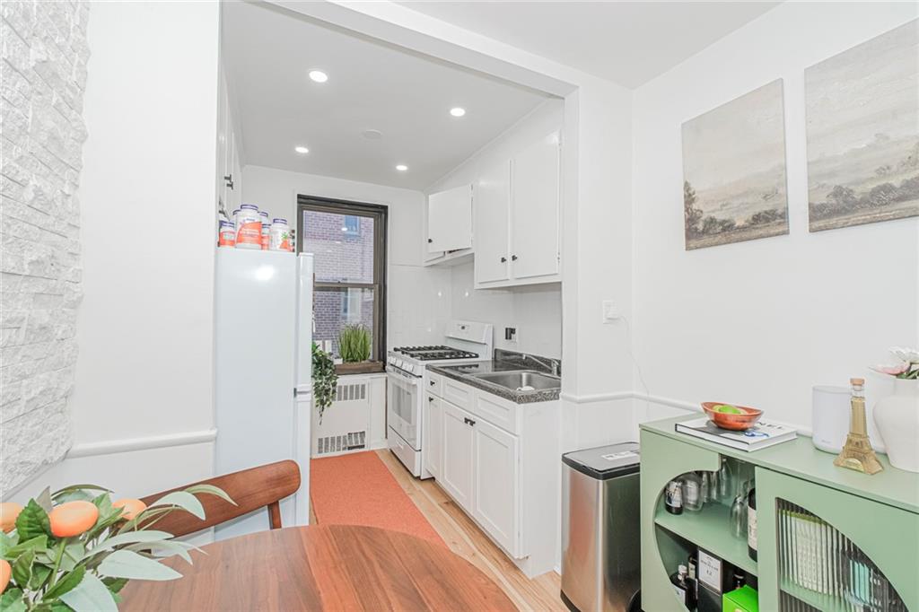 2140 Knapp Street, Unit 5H Brooklyn, NY 11229 - Photo 12 of 21 a kitchen with stainless steel appliances granite countertop a sink and wooden floor