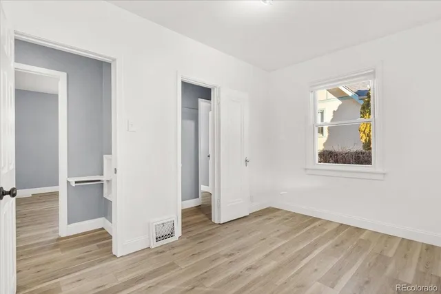 an empty room with wooden floor and a window