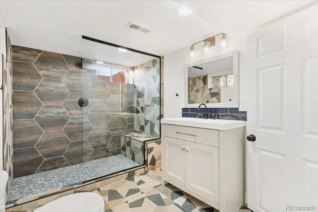 a bathroom with a shower sink and mirror