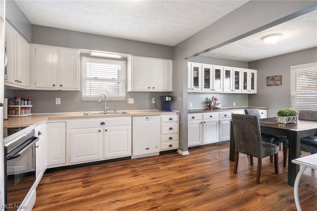 801 Netherwood Avenue Northwest Canton, OH 44708 - Photo 10 of 44 Kitchen featuring lvt wood-style flooring, white cabinetry, dishwasher, sink, stove and plenty of counterspace