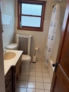 a bathroom with a sink toilet and window