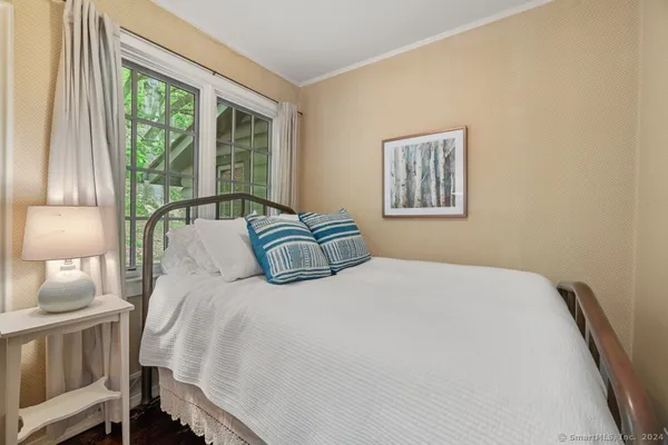 a bedroom with a bed and a large window