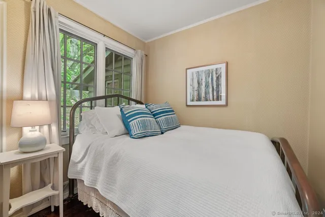 a bedroom with a bed and a large window