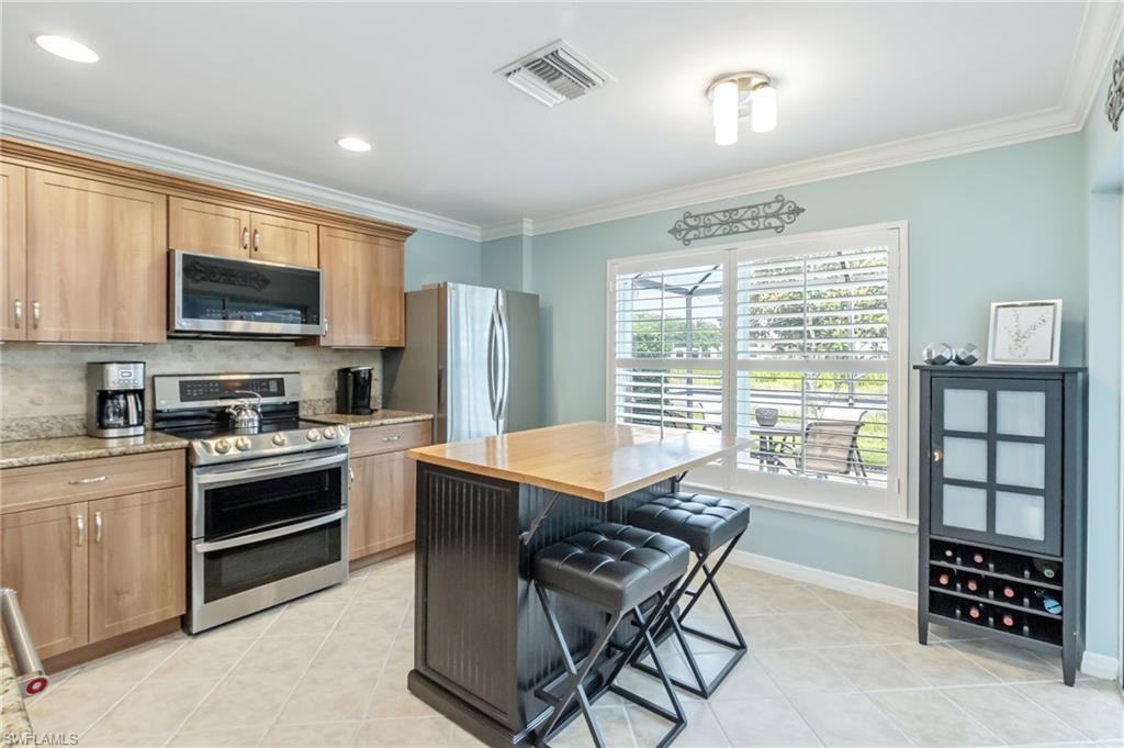 5801 Declaration Court Ave Maria, FL 34142 - Photo 7 of 38 a kitchen with a stove a sink and a microwave