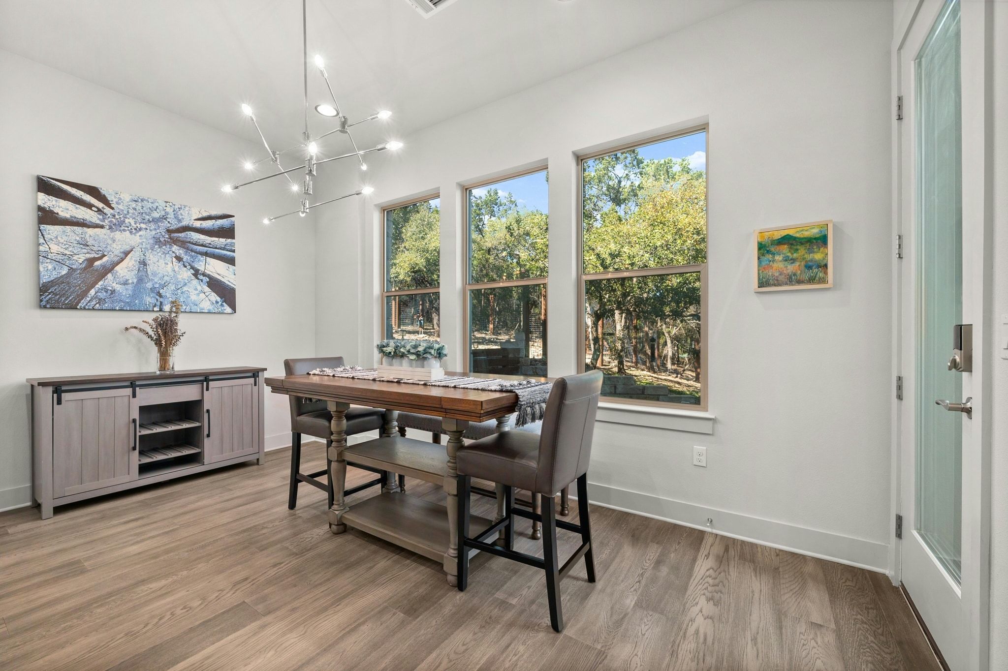8110 Ranch Road 2222, Unit 92 Austin, TX 78730 - Photo 12 of 40 Dining area featuring wood-finish flooring, a modern linear chandelier, and three large windows