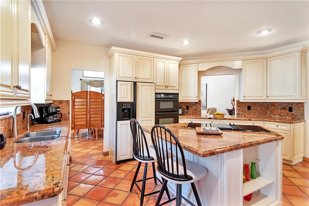 6396 Via Rosa Boca Raton, FL 33433 - Photo 8 of 30 a kitchen with stainless steel appliances granite countertop a stove top oven a sink a dining table and chairs