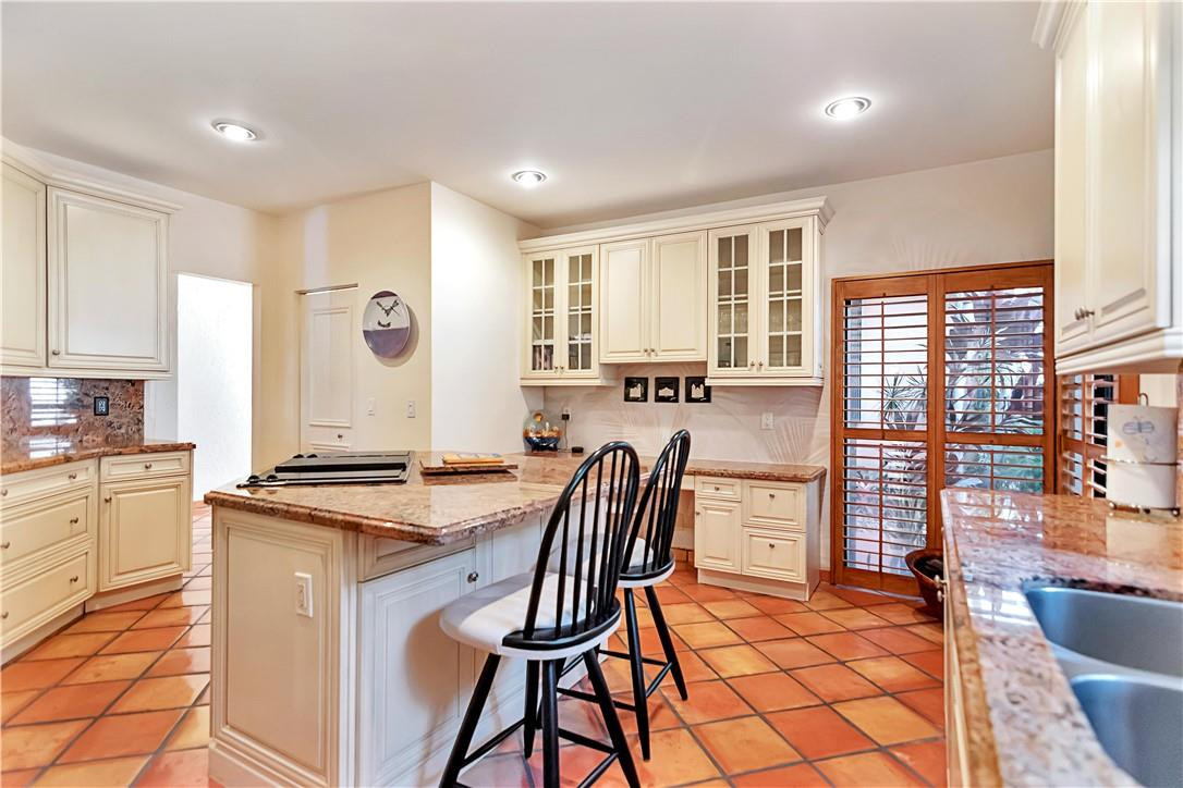 6396 Via Rosa Boca Raton, FL 33433 - Photo 10 of 30 a kitchen with stainless steel appliances granite countertop a stove top oven a sink a dining table and chairs