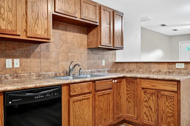 a kitchen with stainless steel appliances granite countertop a sink dishwasher a stove and cabinets with wooden floor