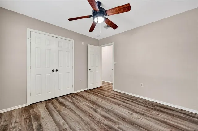a view of room with hardwood floor and ceiling fan