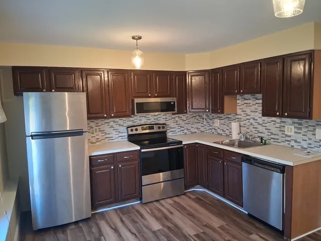 a kitchen with stainless steel appliances granite countertop a refrigerator stove a sink and dishwasher