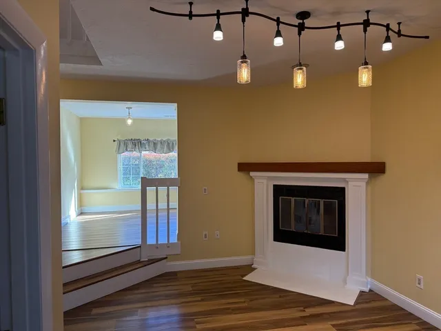 a view of a livingroom with wooden floor and brick walls