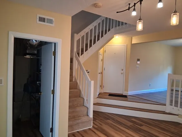 a view of entryway and hall with wooden floor