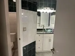 a bathroom with a granite countertop sink and mirror
