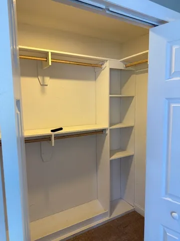 a view of walk in closet with empty racks