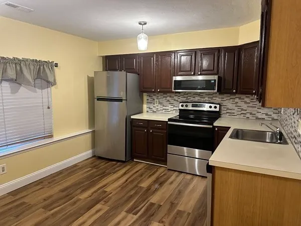 a kitchen with wooden cabinets and stainless steel appliances