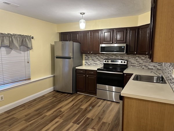 191 Tall Oaks Drive, Unit C Weymouth, MA 02190 - Photo 2 of 24 a kitchen with wooden cabinets and stainless steel appliances