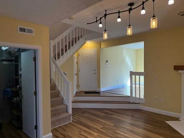 a view of entryway and hall with wooden floor