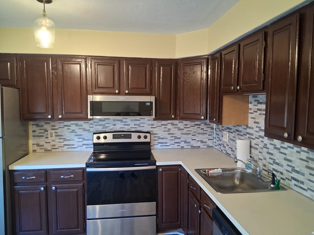 191 Tall Oaks Drive, Unit C Weymouth, MA 02190 - Photo 4 of 24 a kitchen with wooden cabinets and a stove top oven
