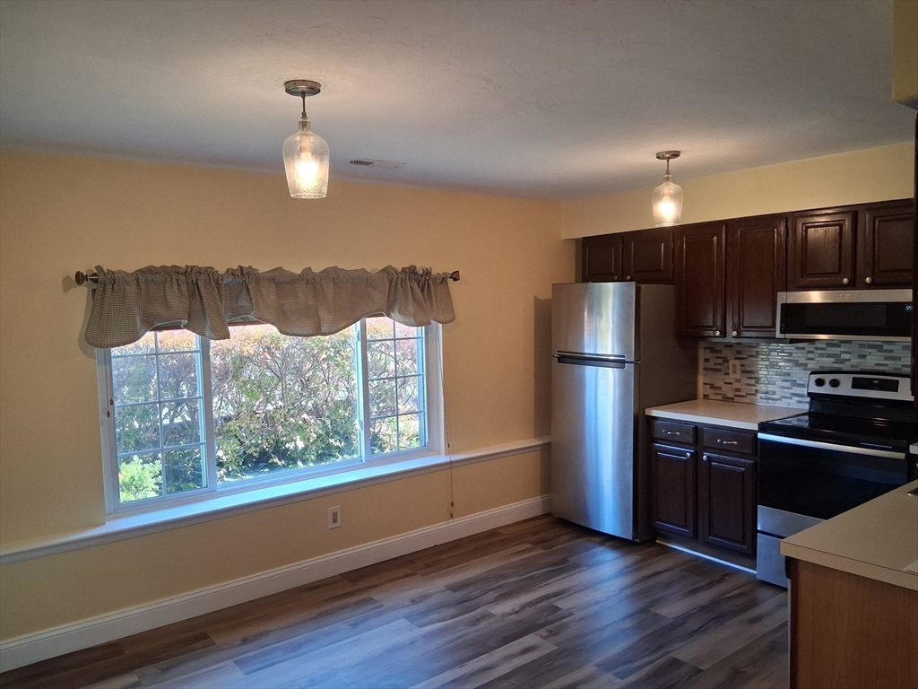 191 Tall Oaks Drive, Unit C Weymouth, MA 02190 - Photo 5 of 24 a kitchen with stainless steel appliances granite countertop a refrigerator and a sink