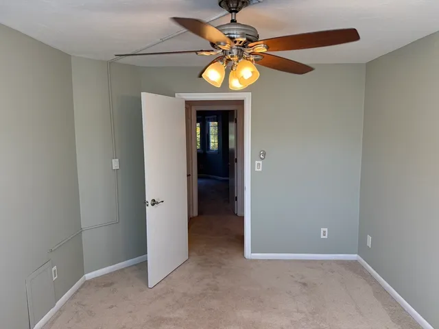 an empty room with a chandelier and a ceiling fan