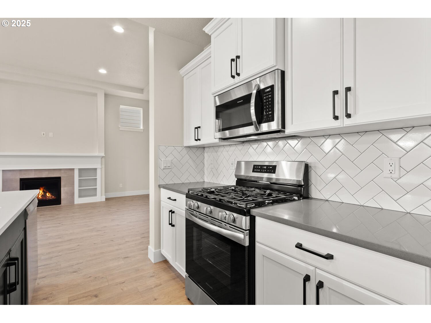 1100 North 44th Place Ridgefield, WA 98642 - Photo 11 of 29 a kitchen with stainless steel appliances white cabinets and stove top oven