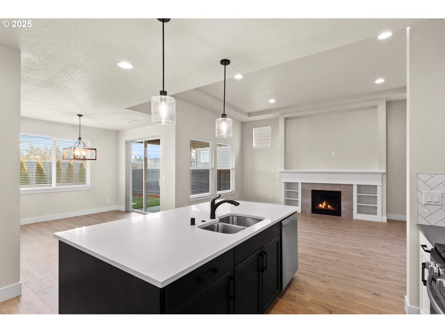 1100 North 44th Place Ridgefield, WA 98642 - Photo 10 of 29 a kitchen with a sink a chandelier and a fireplace