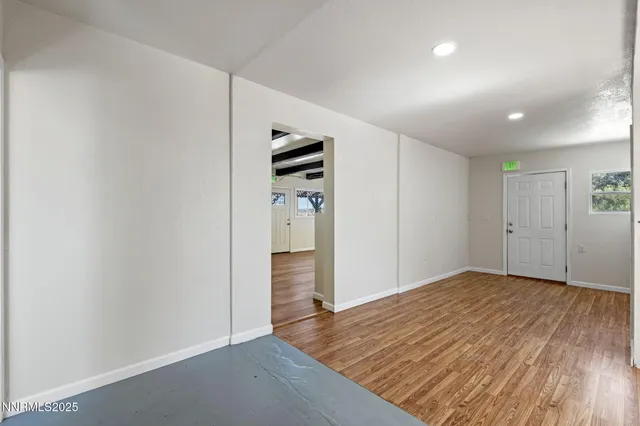 a view of an empty room with wooden floor